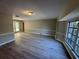 Spacious living room featuring new gray laminate flooring, white molding, and bright bay windows at 726 Chevy Chase St, Port Charlotte, FL 33948