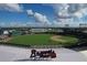 Aerial view showcases the community's baseball park with the stadium, green fields, and blue skies with white clouds at 7280 Muncey Rd, North Port, FL 34291