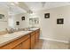 Well-lit bathroom with double sinks, ample counter space, framed mirrors, and tile flooring at 7280 Muncey Rd, North Port, FL 34291