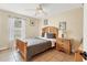 Cozy bedroom featuring a wooden bed frame, neutral walls, tile floor, and a window providing soft natural light at 7280 Muncey Rd, North Port, FL 34291