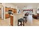 Open kitchen featuring oak cabinetry, a breakfast bar, and seamless flow into the living room at 7280 Muncey Rd, North Port, FL 34291
