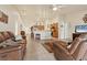 Spacious living room featuring tile flooring, leather seating, and an open layout connecting to the kitchen at 7280 Muncey Rd, North Port, FL 34291