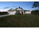 Inviting home exterior displaying modern design, lush lawn, and an attached garage in a serene setting at 7345 Ellis Ln, Port Charlotte, FL 33981