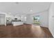 Spacious open-concept living area features a modern kitchen, wood-look floors, and sliding glass doors at 7345 Ellis Ln, Port Charlotte, FL 33981