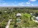 Expansive property featuring a serene pond, lush greenery, and multiple structures captured in an aerial shot at 7424 Acorn Blvd, Punta Gorda, FL 33982