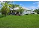 Well-maintained exterior with a lush green lawn and mature trees providing shade and privacy at 7424 Acorn Blvd, Punta Gorda, FL 33982
