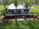 Charming single story home with a metal roof, front porch, walkway, and mature landscaping at 7424 Acorn Blvd, Punta Gorda, FL 33982