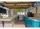 Outdoor kitchen area featuring ample counter space, a sink, and a refrigerator to keep drinks cold at 7424 Acorn Blvd, Punta Gorda, FL 33982