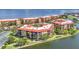 Aerial view of condos with red roofs on waterfront property with beautiful landscaping at 90 Vivante Blvd # 202, Punta Gorda, FL 33950