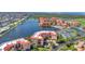 An aerial view of a waterfront condo community with tennis courts, a pool, and waterways at 90 Vivante Blvd # 202, Punta Gorda, FL 33950