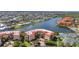 Stunning aerial view of a condo community featuring a lake, tennis courts, and lush landscaping at 90 Vivante Blvd # 202, Punta Gorda, FL 33950