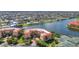 Beautiful aerial view of condo buildings with red tile roofs, lush landscaping, and lake views at 90 Vivante Blvd # 202, Punta Gorda, FL 33950