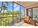 Screened-in balcony with wicker furniture and palm tree views at 90 Vivante Blvd # 202, Punta Gorda, FL 33950