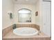 Relaxing bathroom featuring a jacuzzi tub, tiled surround, and a view into an adjacent bathroom, offering a luxurious retreat at 90 Vivante Blvd # 202, Punta Gorda, FL 33950