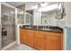 Well-lit bathroom with double sinks and granite countertops, complemented by a tiled shower and large mirror at 90 Vivante Blvd # 202, Punta Gorda, FL 33950