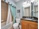Traditional bathroom featuring tile walls, granite counter and shower/tub with curtain at 90 Vivante Blvd # 202, Punta Gorda, FL 33950