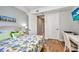 Bright bedroom with wooden floors, a double bed and a view through an open closet space at 90 Vivante Blvd # 202, Punta Gorda, FL 33950