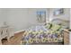 Cozy bedroom featuring a floral comforter, window with natural light, and white wood flooring at 90 Vivante Blvd # 202, Punta Gorda, FL 33950