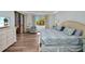 Bright bedroom featuring a comfortable bed with blue patterned bedding and a sliding door to a private lanai at 90 Vivante Blvd # 202, Punta Gorda, FL 33950