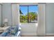 Bedroom view showcasing a serene lake and lush greenery, visible through a large window framed by elegant curtains at 90 Vivante Blvd # 202, Punta Gorda, FL 33950