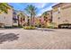 Elegant condo exterior with palm trees, a circular driveway, and covered parking at 90 Vivante Blvd # 202, Punta Gorda, FL 33950
