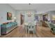 Charming dining area with wood flooring, a stylish chandelier, and views into the living room at 90 Vivante Blvd # 202, Punta Gorda, FL 33950