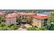 Mediterranean style condo building with a red roof and lush landscaping at 90 Vivante Blvd # 202, Punta Gorda, FL 33950