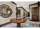 Elegant hallway featuring decorative mirror, patterned table, and stylish decor, leading to wood panel doors at 90 Vivante Blvd # 202, Punta Gorda, FL 33950