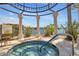 Hot tub with decorative columns, metal dome, and tiled deck overlooking a serene lake, offering a relaxing spa experience at 90 Vivante Blvd # 202, Punta Gorda, FL 33950