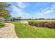 Community walkway with lush green lawns, flowering shrubs, and a tranquil water view, creating a serene and inviting outdoor space at 90 Vivante Blvd # 202, Punta Gorda, FL 33950