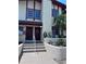 Close up of condo entrance with decorative landscaping, steps, and two entry doors at 93 Boundary Blvd # 303, Rotonda West, FL 33947