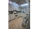 White kitchen boasts ample cabinet space, tiled floor and modern appliances at 93 Boundary Blvd # 303, Rotonda West, FL 33947