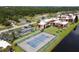 Aerial view of a community tennis court, condos, parking and green space at 93 Boundary Blvd # 303, Rotonda West, FL 33947