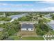 Aerial view of a home near a lake showcasing the surrounding neighborhood and lush landscaping at 165 Ingram Blvd, Rotonda West, FL 33947