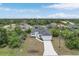 Stunning aerial view of a modern home with a long driveway and lush landscaping at 165 Ingram Blvd, Rotonda West, FL 33947