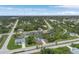 Expansive aerial view showcasing the neighborhood with mature trees and a serene waterway at 165 Ingram Blvd, Rotonda West, FL 33947
