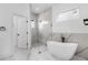 Modern bathroom with a luxurious freestanding tub and glass-enclosed shower with marble tile at 165 Ingram Blvd, Rotonda West, FL 33947