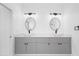 Modern bathroom featuring double sinks, sleek gray cabinetry, and contemporary lighting fixtures above the mirrors at 165 Ingram Blvd, Rotonda West, FL 33947