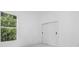 Bright bedroom with a window view of lush greenery and a modern sliding door closet for ample storage at 165 Ingram Blvd, Rotonda West, FL 33947