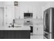 Modern kitchen boasts sleek white cabinets, stainless steel appliances, and a stylish, dark-toned kitchen island at 165 Ingram Blvd, Rotonda West, FL 33947