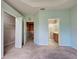 A bedroom with neutral carpet, and a view of the ensuite bathroom and walk-in closet at 1273 Jonah Dr, North Port, FL 34289