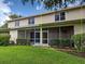 Back exterior elevation of the home featuring a screened-in porch and well-maintained landscaping at 1273 Jonah Dr, North Port, FL 34289