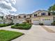 Townhome complex with well-manicured lawns, lush landscaping, and attached garages at 1273 Jonah Dr, North Port, FL 34289