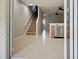 View of the foyer with staircase and stainless steel dishwasher and light brown tile flooring at 1273 Jonah Dr, North Port, FL 34289