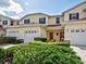 Townhome featuring a red front door, garage, and well-maintained landscaping at 1273 Jonah Dr, North Port, FL 34289