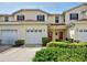 Charming townhome featuring a red front door, garage, and well-maintained landscaping at 1273 Jonah Dr, North Port, FL 34289