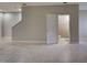 Spacious living room with tile flooring, leading to a bathroom and staircase at 1273 Jonah Dr, North Port, FL 34289