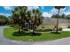 Rear home view featuring a screened in porch, lush landscaping and mature shade trees at 1318 Red Oak Ln, Port Charlotte, FL 33948