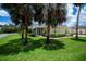 Back exterior view of home showcasing screened-in porch and well-kept lawn at 1318 Red Oak Ln, Port Charlotte, FL 33948
