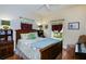 Cozy bedroom with a wooden bed frame, colorful floral bedding, and natural light from two windows at 1318 Red Oak Ln, Port Charlotte, FL 33948